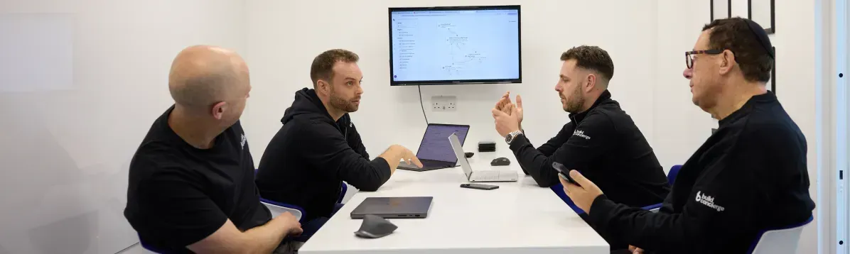 Build Concierge team sitting around a white table with computers