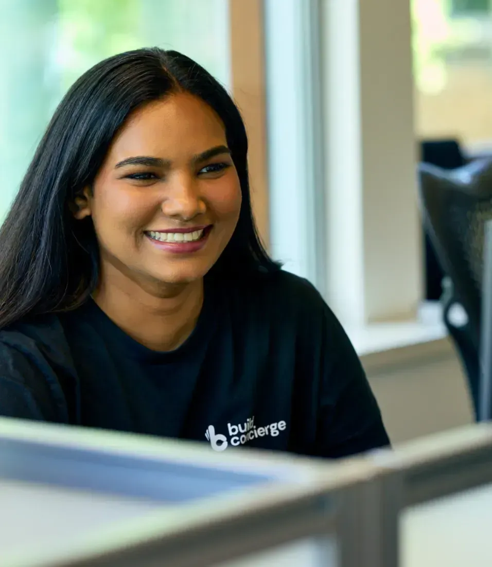 A developer at Build Concierge, smiling at a colleague. 